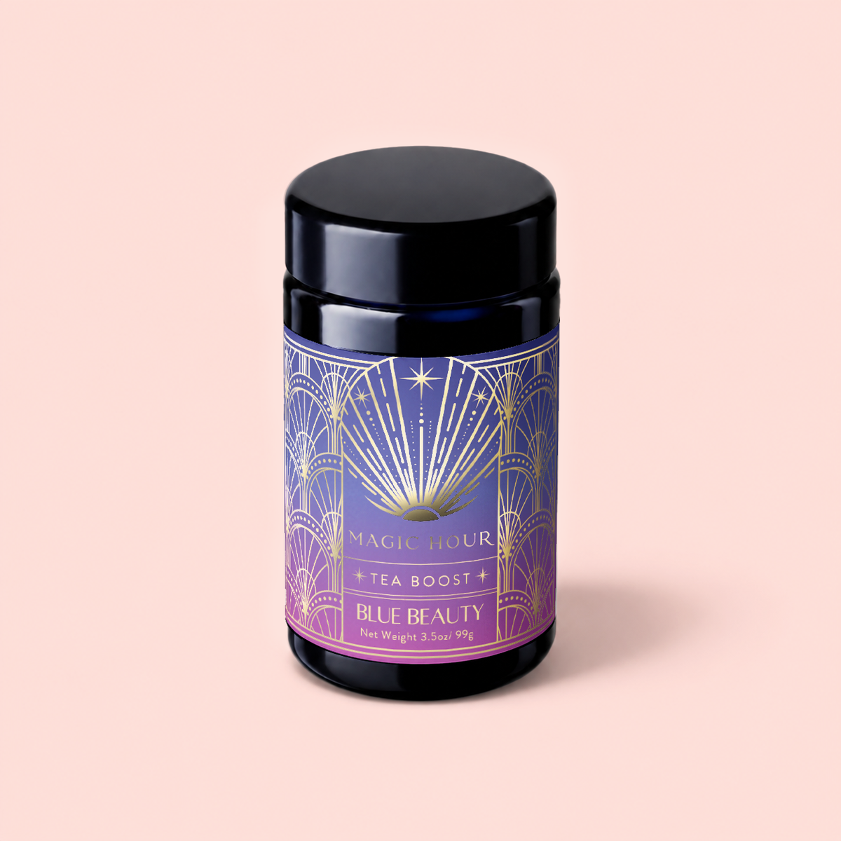 A black canister of Magic Hour’s Blue Beauty: Butterfly Pea Flower Powder Boost tea with an art deco label in blue, gold, and purple—adorned with sun and starburst motifs—set against a soft pink background. This blend features butterfly pea flower powder, celebrated for supporting collagen production and promoting radiant skin.
