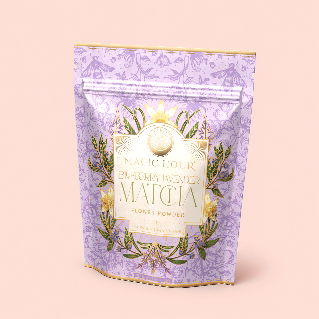 A lavender-colored pouch of Flower Powder: Blueberry Lavender Matcha with gold accents and floral designs, standing upright on a light pink background—perfect for those seeking a calming tea experience with the delicate flavors of blueberry matcha.