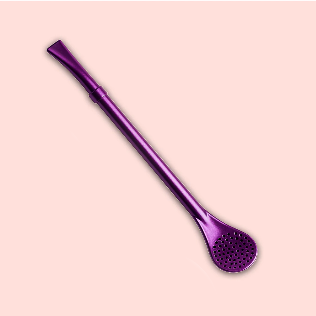 The Beauty Inside &amp; Out Box features a metallic purple bombilla with a flat mouthpiece and perforated spoon filter, perfect for yerba mate or tea ceremonies, showcased on a light pink background.