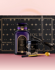 The Tea & Honey Gift Set is a luxurious morning gift, featuring a black "Magic Hour" box, purple coconut chai tea bottle, wildflower honey with golden dipper, and black ribbon, all arranged on a pink background.