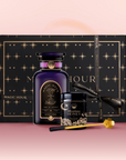 The Tea & Honey Gift Set features a black and gold star-patterned box, dark purple "Magic Hour" bottle, wildflower honey, and a golden honey dipper—all arranged on a pink background for your perfect morning ritual.