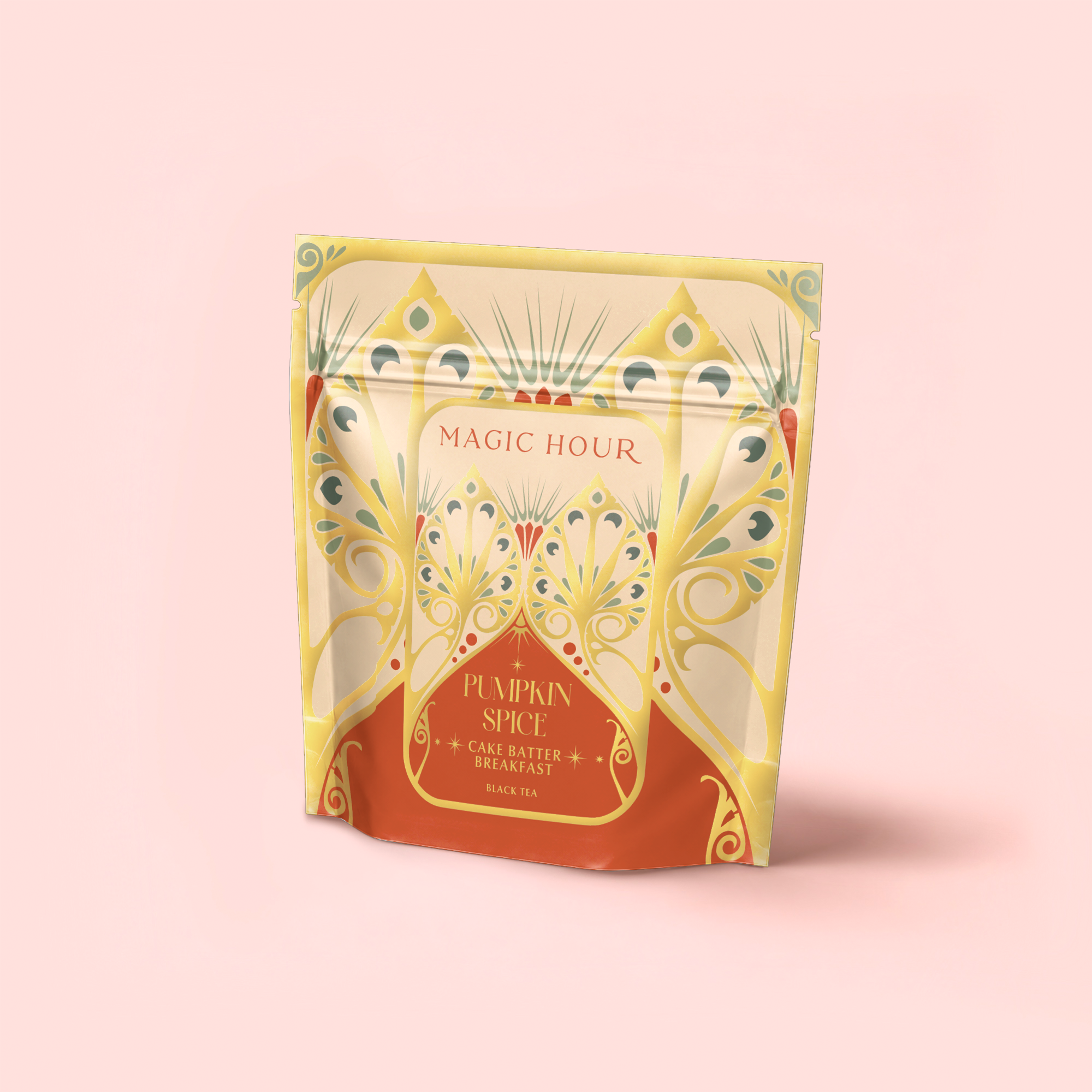 A decorative pouch of Pumpkin Spice Cake Batter Breakfast stands upright against a pale pink background. The ornate packaging features yellow, green, and orange designs and contains organic black tea for a delicious morning treat.