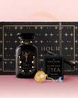 The Cancer Astrology Tea Gift Set includes a black and gold "Cancer" perfume bottle, Cancer Zodiac Tea in a black Opal Moon Ritual Tea box, a gold tea infuser, and comes packaged in a star-studded black gift box.