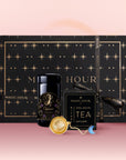 The Capricorn Astrology Tea Gift Set features a black and gold Magic Hour box with star designs, a black tea jar, a gold Opalite Moon Tea Strainer, and an astrology ritual tag on a pink gradient background.