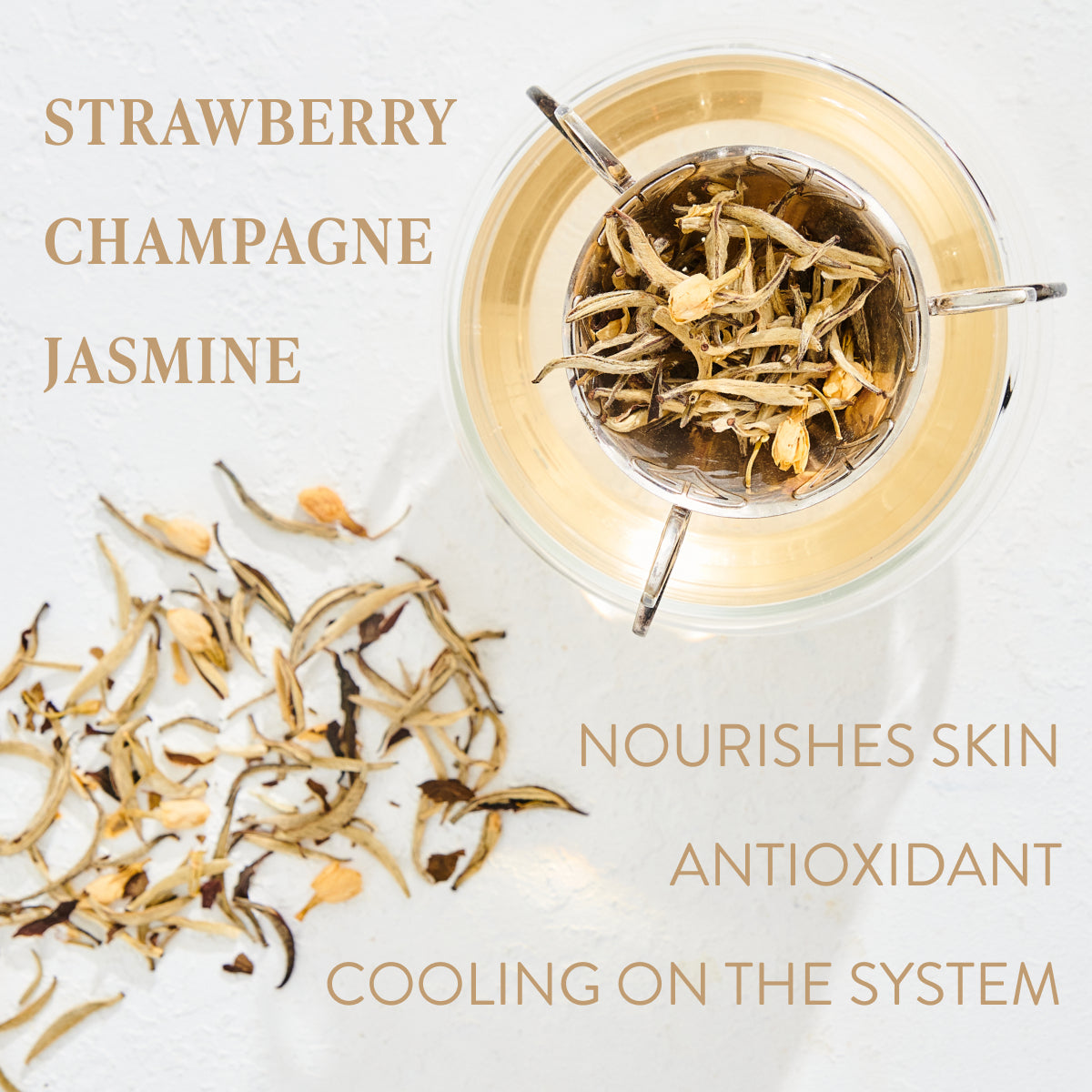 Top-down view of a glass teacup with steeped light-colored organic tea and loose leaf tea scattered around it. The words "STRAWBERRY, CHAMPAGNE, JASMINE" are on the left, while "NOURISHES SKIN, ANTIOXIDANT, COOLING ON THE SYSTEM" are on the right. Experience the Magic Hour Diamond - Champagne & Strawberry Jasmine White Tea for Beautiful Skin moment.