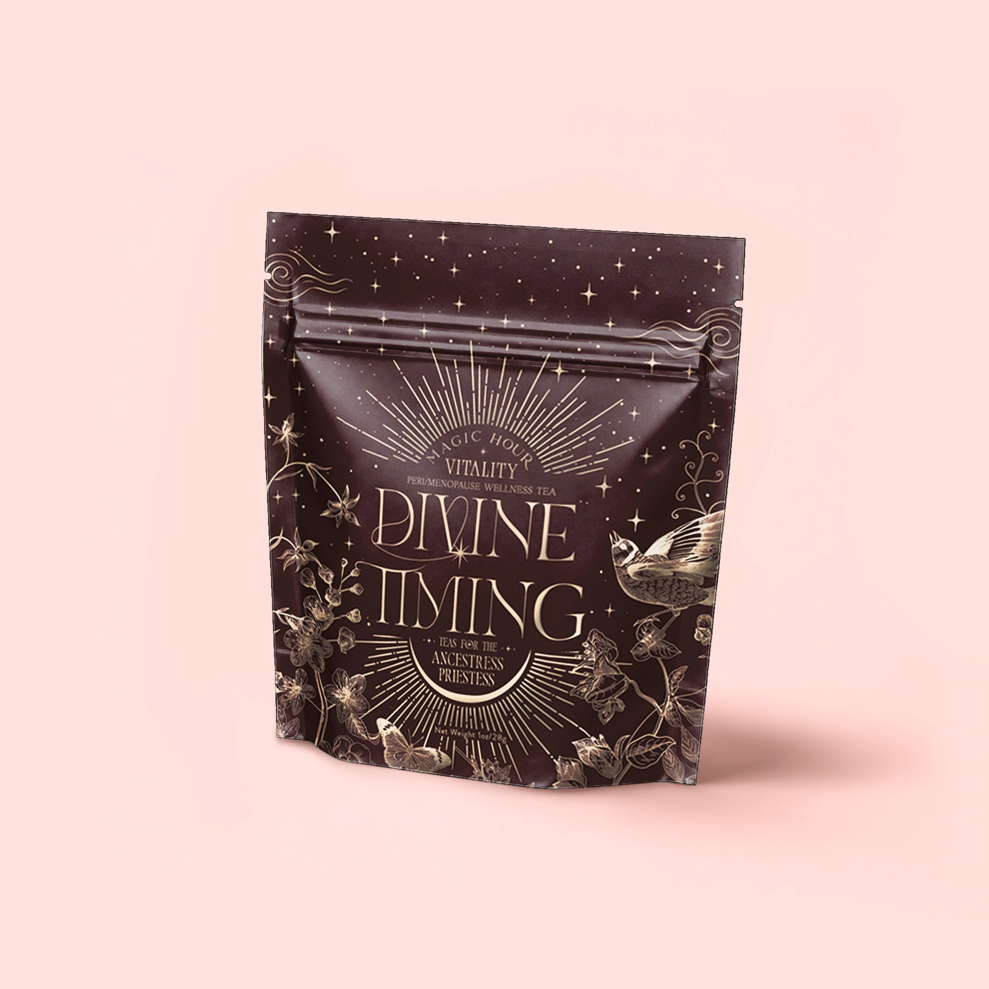 A resealable tea package labeled “Divine Timing Vitality” displays celestial and botanical art—stars, flowers, a bird—symbolizing the adaptogenic tea's natural benefits, set on a deep brown backdrop atop a light pink surface.
