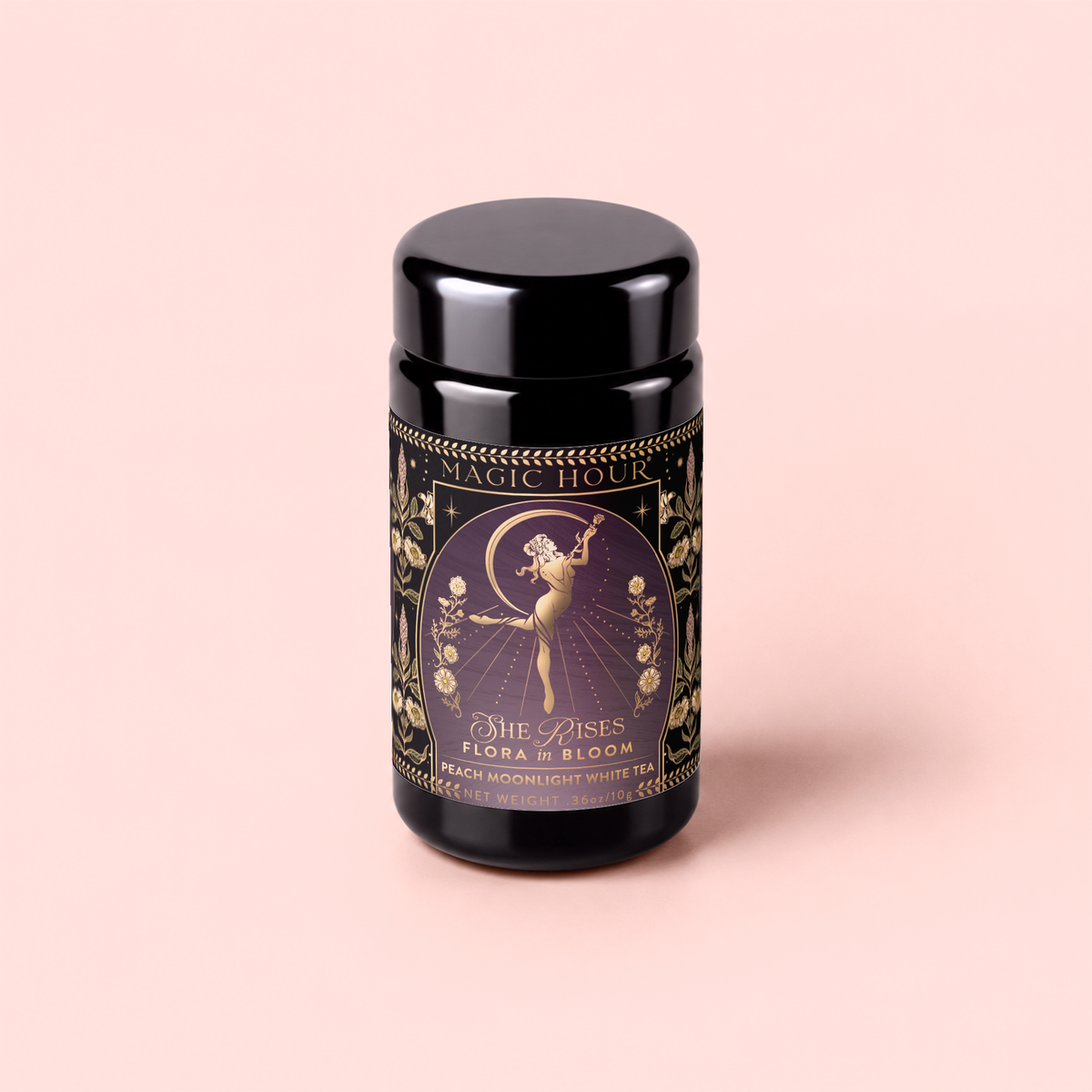 A beautifully designed black tea canister labeled “Magic Hour” features a dancing woman with flowers, gold accents, and the text “Flora In Bloom: Peach Moonlight White Tea, The Pisces” on a light pink background. This elegant canister celebrates the delicate essence of Yue Guang Bai—also known as Moonlight White Tea—one of the most enchanting white teas.