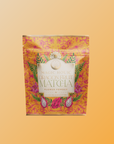 A vibrant pouch of Flower Powder: Dragon Fruit Matcha, made with organic ceremonial matcha from Kagoshima, sits on an orange background. The packaging features dragon fruit images and floral designs.