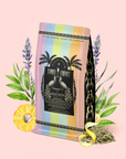 A vibrant bag of French 75: Lemon Sparkling Wine White Mocktail Tea for Cool, Calm Radiance sits against a pastel pink background, adorned with tropical and botanical details like pineapple, French lavender, lemon slices, and green leaves. The packaging showcases playful palm tree and peacock illustrations—perfect for creating a wellness mocktail centered around Silver Needle white tea.