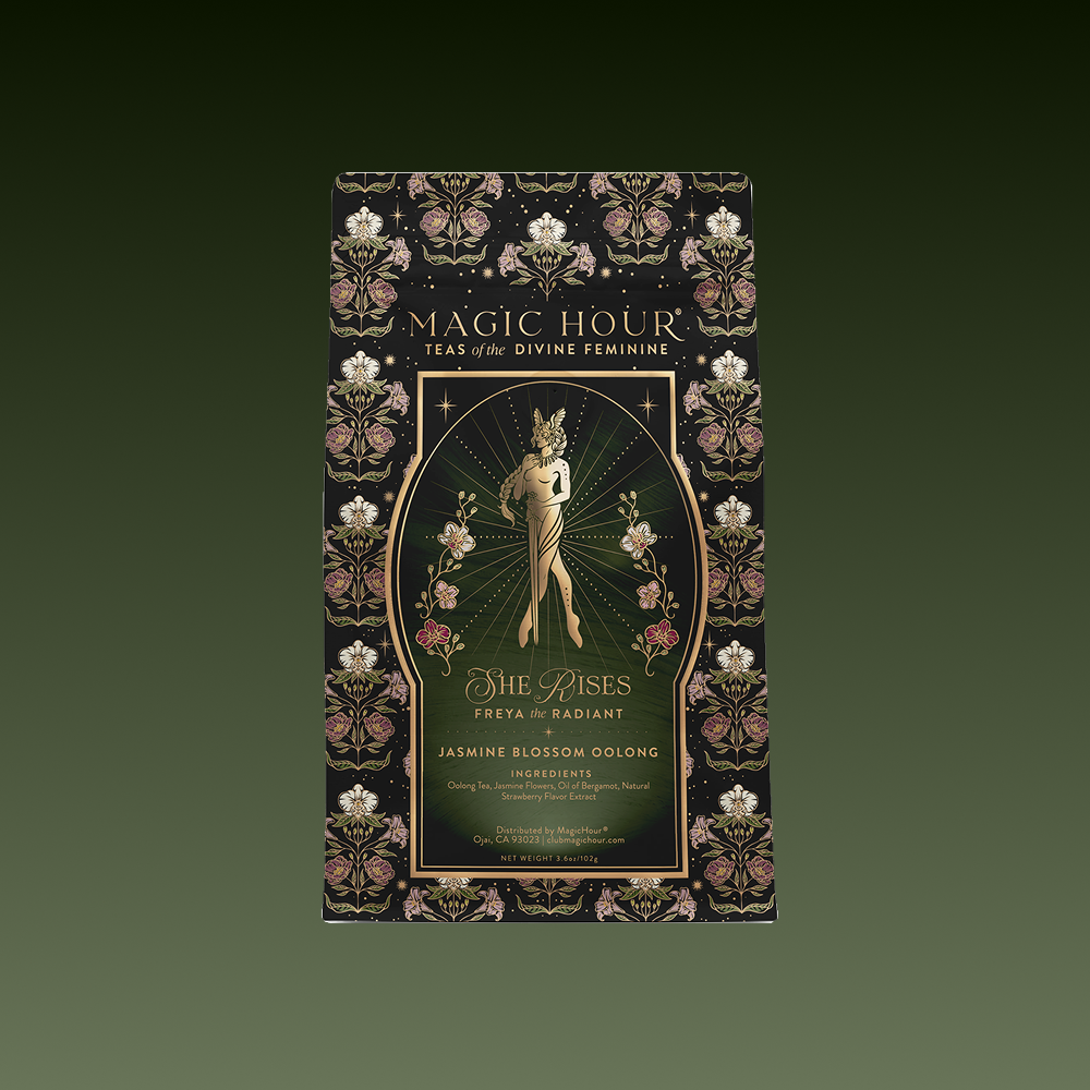 A decorative tea package labeled "Freya: The Radiant" features a golden female figure with flowers, ornate borders, and "She Rises: Jasmine Oolong Tea" on a dark background.