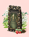 A package of "Freya The Radiant: Jasmine Bai Hao Oolong with Bergamot & Berry" stands among white jasmine flowers, green leaves, loose Bai Hao (Oriental Beauty Oolong) tea, and strawberries on a light pink background.