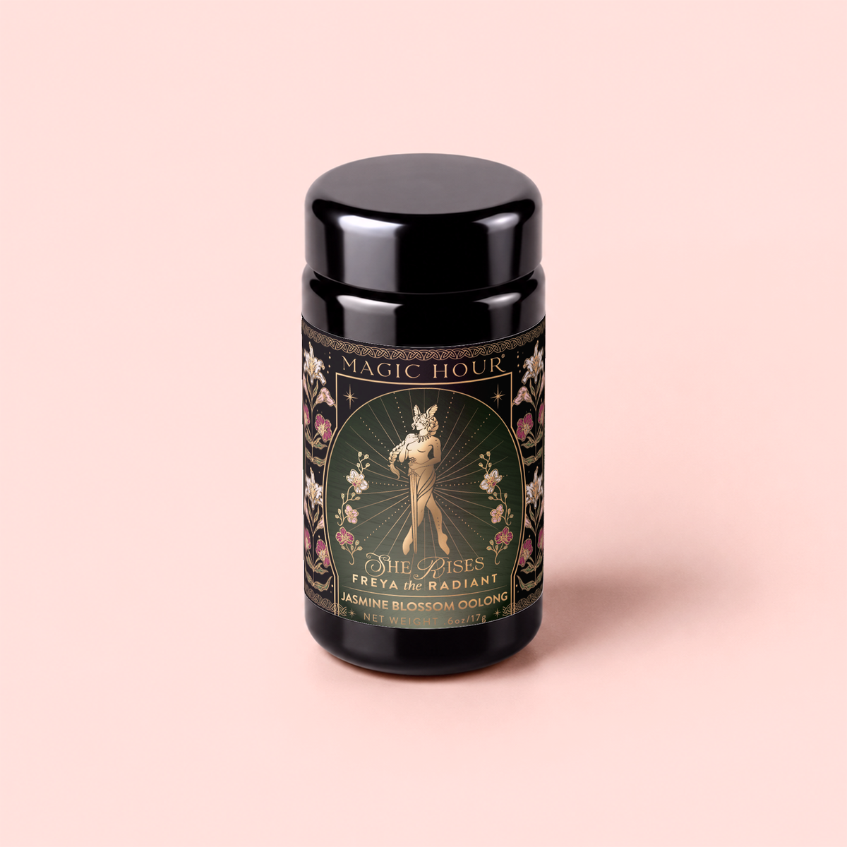 A black tea canister labeled “Freya The Radiant: Jasmine Bai Hao Oolong with Bergamot &amp; Berry,” featuring an ornate floral design and an illustration of a woman holding flowers, inspired by the elegance of Taiwanese tea traditions and the delicate notes found in Oriental Beauty Oolong.