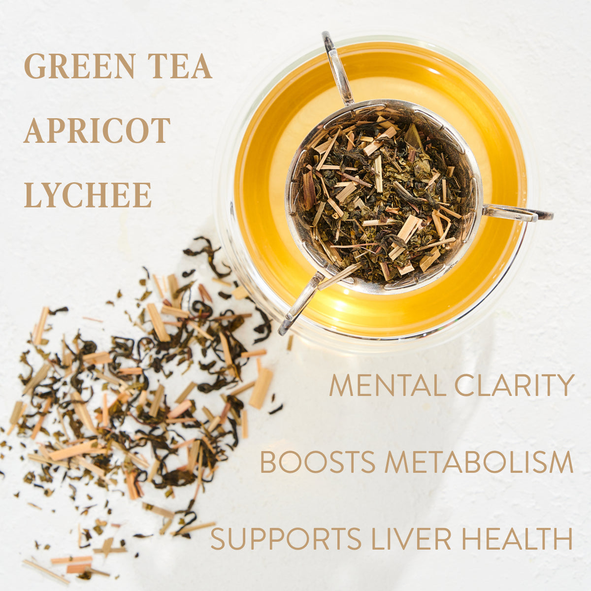 A glass teacup filled with Goddess Green Tea and apricot lychee blend. Loose leaf tea is scattered next to the cup on a white surface. Text on the image reads: &quot;GODDESS GREEN TEA APRICOT LYCHEE MENTAL CLARITY BOOSTS METABOLISM SUPPORTS LIVER HEALTH.&quot; Experience the Magic Hour with organic tea blends.