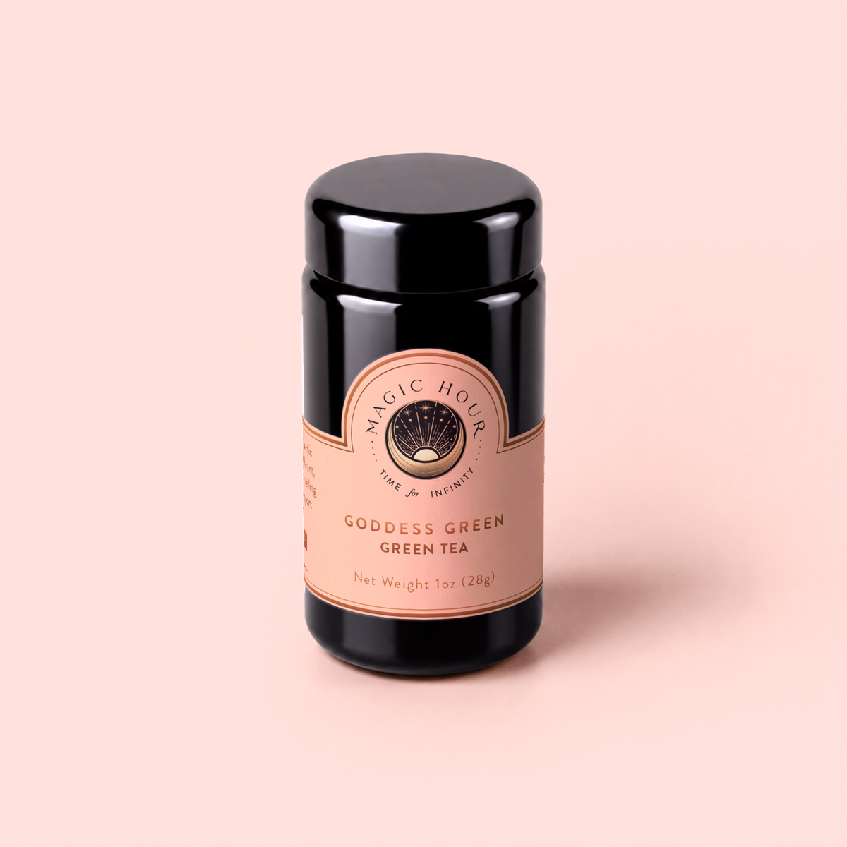 A black cylindrical tin labeled “Goddess Green Tea,” embellished with a peach and gold label, rests on a light peach background. This exquisite blend offers notes of apricot lychee and gentle lemongrass, elevating the classic green tea experience.