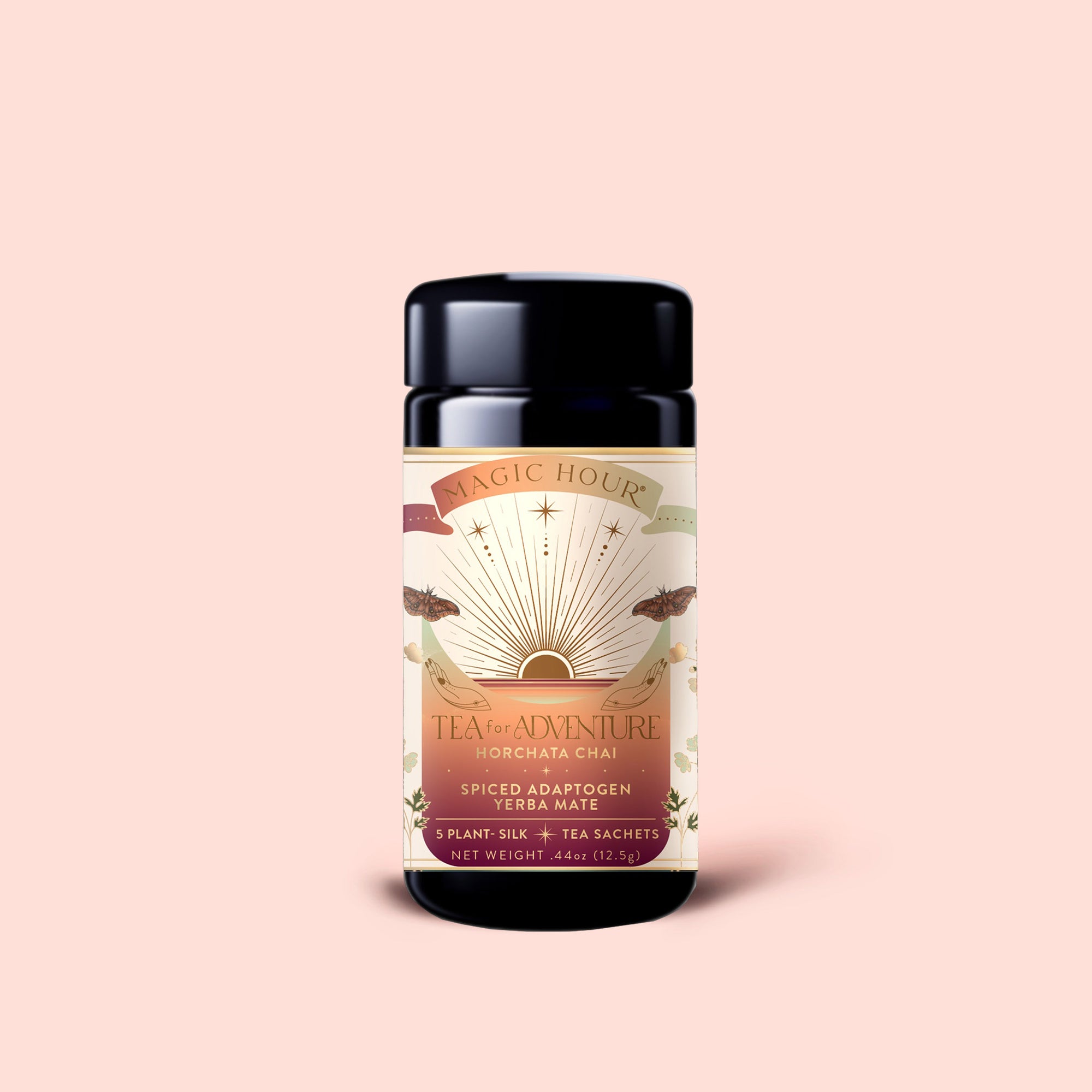 A cylindrical tin labeled "Tea for Adventure: Horchata Chai: Spiced Yerba Mate," featuring a sunrise design inspired by Tulum, contains adaptogen yerba mate horchata chai tea sachets with ashwagandha, and is displayed against a pale pink background.