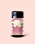 A black tea canister with a pink and gold label reading "Magic Hour Tea for Peace, Child's Pose, Heart Chakra, Citrus Lavender Tulsi" rests against a pale pink background. The Tea for Peace: Child's Pose: Citrus, Lavender & Tulsi Herbal Tea Blend is an adaptogenic infusion thoughtfully crafted to relax your nervous system and invite serenity with every soothing cup.