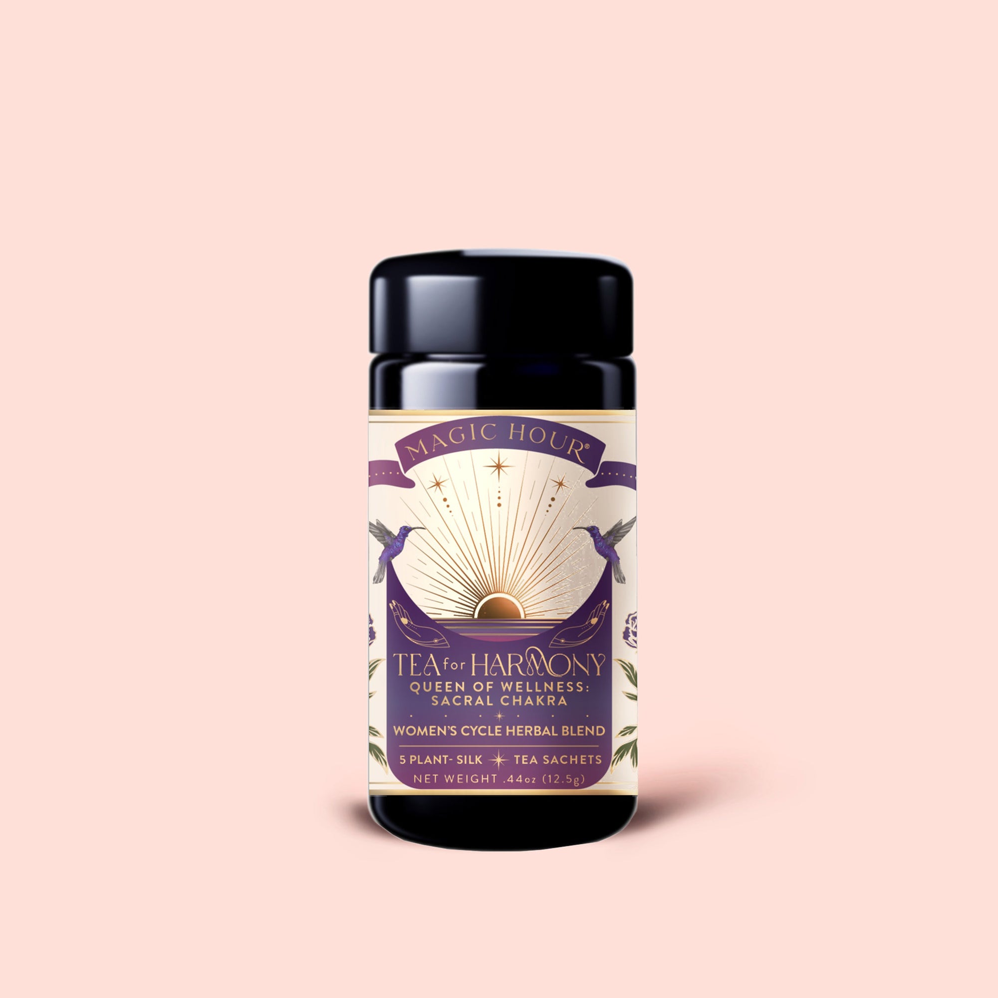 A jar of Tea for Harmony: Queen of Wellness: Women's Cycle Herbal Blend, adorned with a purple and gold label featuring botanical artwork and a sunburst design, set against a light pink background. This women’s herbal tea blends the nurturing qualities of organic chaste berry and calming raspberry leaf tea to help support balance throughout your cycle.