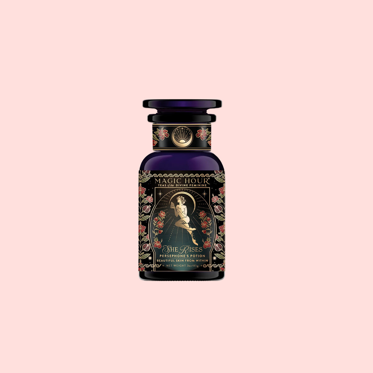 A dark glass bottle of “Persephone’s Potion: Pomegranate &amp; Jasmine Green Tea” features ornate floral designs and an illustration of a woman holding a rose on the label, set against a pale pink background.