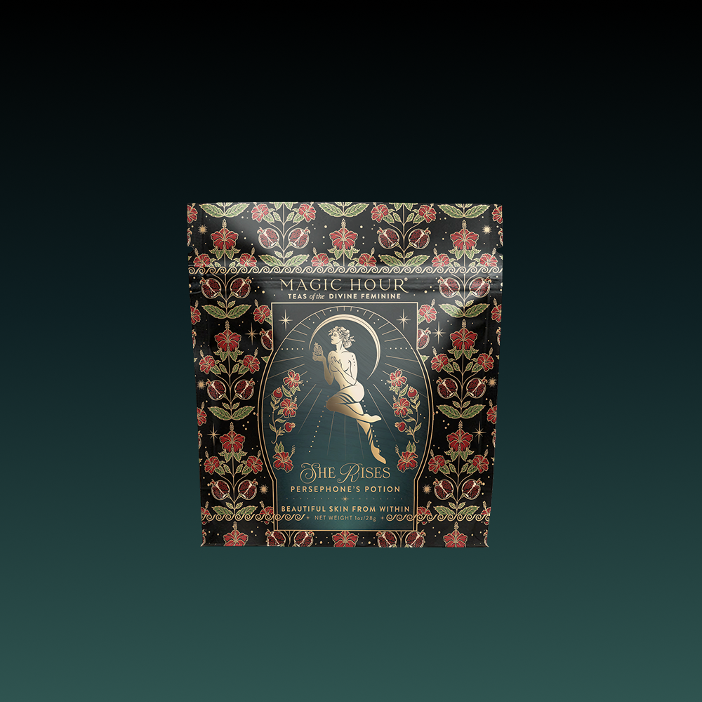 A black tea pouch adorned with gold and red floral patterns features a woman on a crescent moon. The label reads "Magic Hour" and "Persephone’s Potion," included in the Monthly Magic Tea Subscription Box for glowing skin.