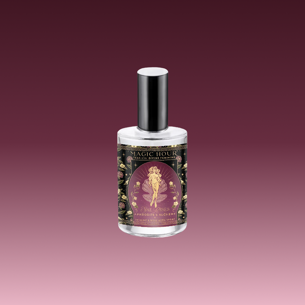 Aphrodite's Alchemy - Jasmine & Rose Beauty Mist comes in a bottle with a silver cap and floral-decorated label featuring a woman on purple, evoking rose hydrosol scents against a gradient burgundy backdrop.