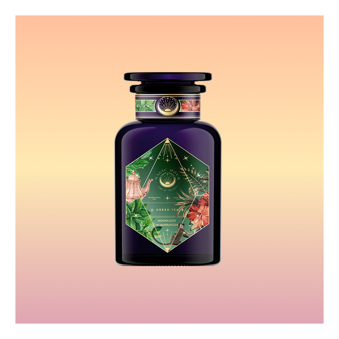 Moonlight in Marrakesh: Spiced Mint Green Tea comes in a dark purple bottle with a green and floral label, gold accents, and botanical art, evoking Moroccan mint tea against a soft peach and pink gradient backdrop.
