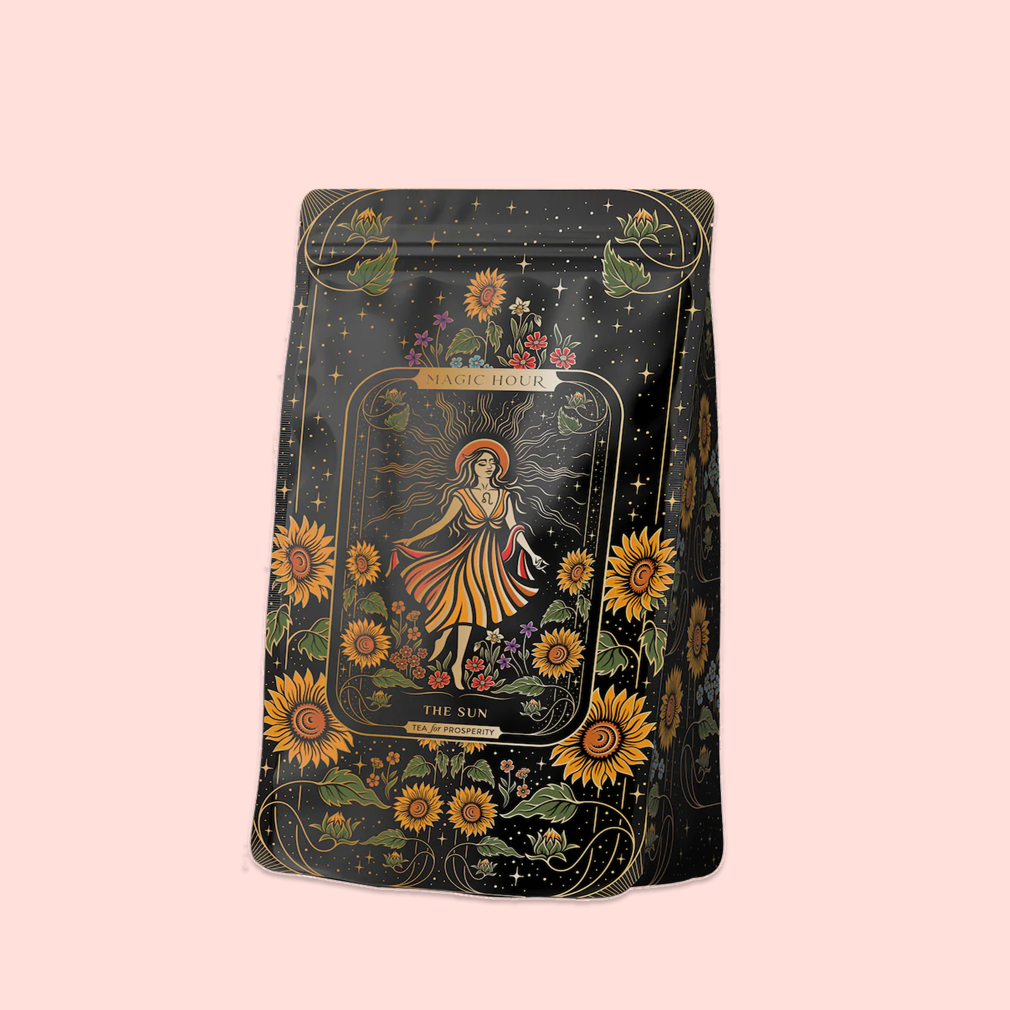 A decorative black tea bag showcases vibrant sunflowers and a woman in orange, with "Magic Hour" and "The Sun" on the front—celebrating The Sun: Energizing Adaptogenic Herbal Tea with Yaupon, Moringa &amp; Turmeric on a light pink background.