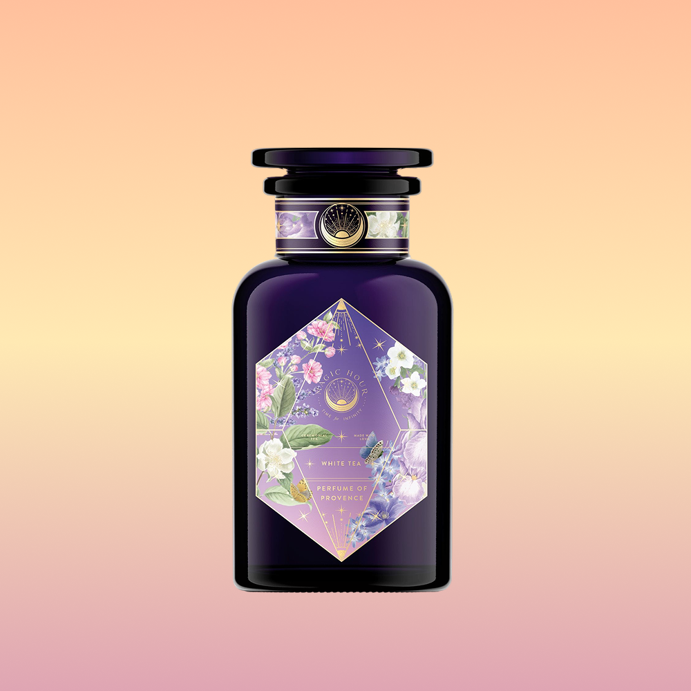 A dark purple perfume bottle with a gold-trimmed cap and a geometric floral label inspired by Provence flower tea displays "Perfumes of Provence: Lavender Bouquet Tea for Calm Moods and Beautiful Skin" on a peach-yellow gradient background.