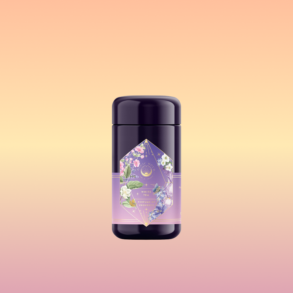 The Perfumes of Provence: Lavender Bouquet Tea for Calm Moods and Beautiful Skin deodorant stick, with a floral geometric label, stands against a soft peach-yellow gradient background, evoking Provence flower tea.