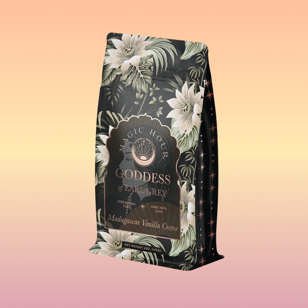 A bag of Goddess of Earl: Madagascar Vanilla Creme Tea for Soothing Delight &amp; Delicious Decadence, with floral, green, and gold designs and "Madagascar Vanilla Creme" text on a pastel gradient background.