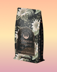 A bag of Goddess of Earl: Madagascar Vanilla Creme Tea for Soothing Delight & Delicious Decadence, with floral, green, and gold designs and "Madagascar Vanilla Creme" text on a pastel gradient background.
