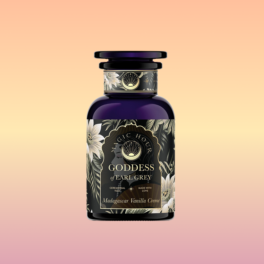 A dark purple bottle labeled "Goddess of Earl: Madagascar Vanilla Creme Tea for Soothing Delight & Delicious Decadence" features floral designs on a pastel background; this organic blend combines Ceylon, Assam, and Yunnan black teas.
