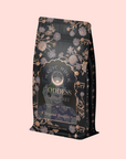 A decorative black and gold tea bag labeled "Goddess of Earl: Lady Luck Oriental Beauty Oolong Tea" features floral and star illustrations, exuding elegance and mystique inspired by premium oolong tea flavors.