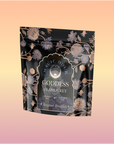 A black and gold floral pouch labeled "Goddess of Earl: Lady Luck Oriental Beauty Oolong Tea" stands against a pink-orange gradient background. The elegant packaging showcases botanical designs and hints of bergamot grapefruit tea.