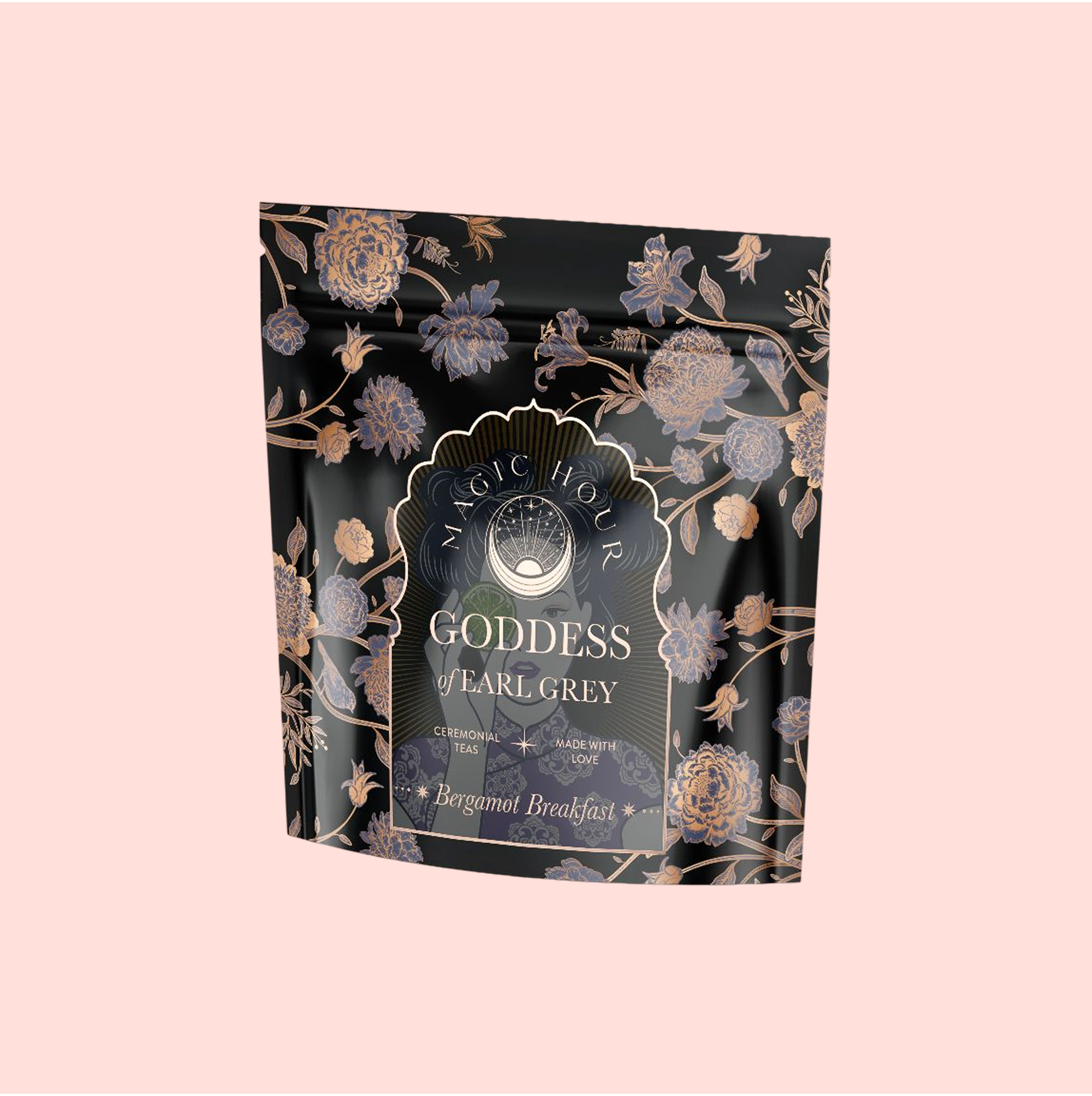A black and gold floral pouch labeled "Goddess of Earl: Lady Luck Oriental Beauty Oolong Tea," adorned with ornate flower designs, sits on a pale pink background, highlighting this unique bergamot oolong blend.