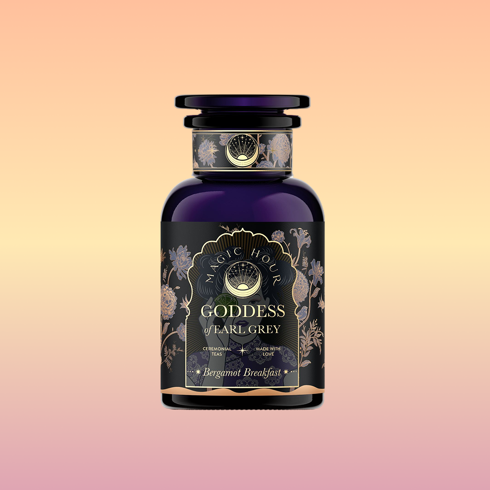 A dark purple glass jar labeled "Goddess of Earl: Lady Luck Oriental Beauty Oolong Tea" features elegant gold and floral designs, set against a soft peach-to-purple gradient background, evoking the allure of Oriental Beauty Oolong tea.
