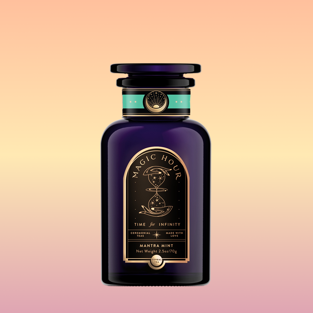A dark purple bottle labeled "Magic Hour" with gold and turquoise accents features an hourglass illustration. The label reads "Time for Infinity" and "Mantra Mint™ Herbal Tea," a caffeine-free blend with soothing Ashwagandha.