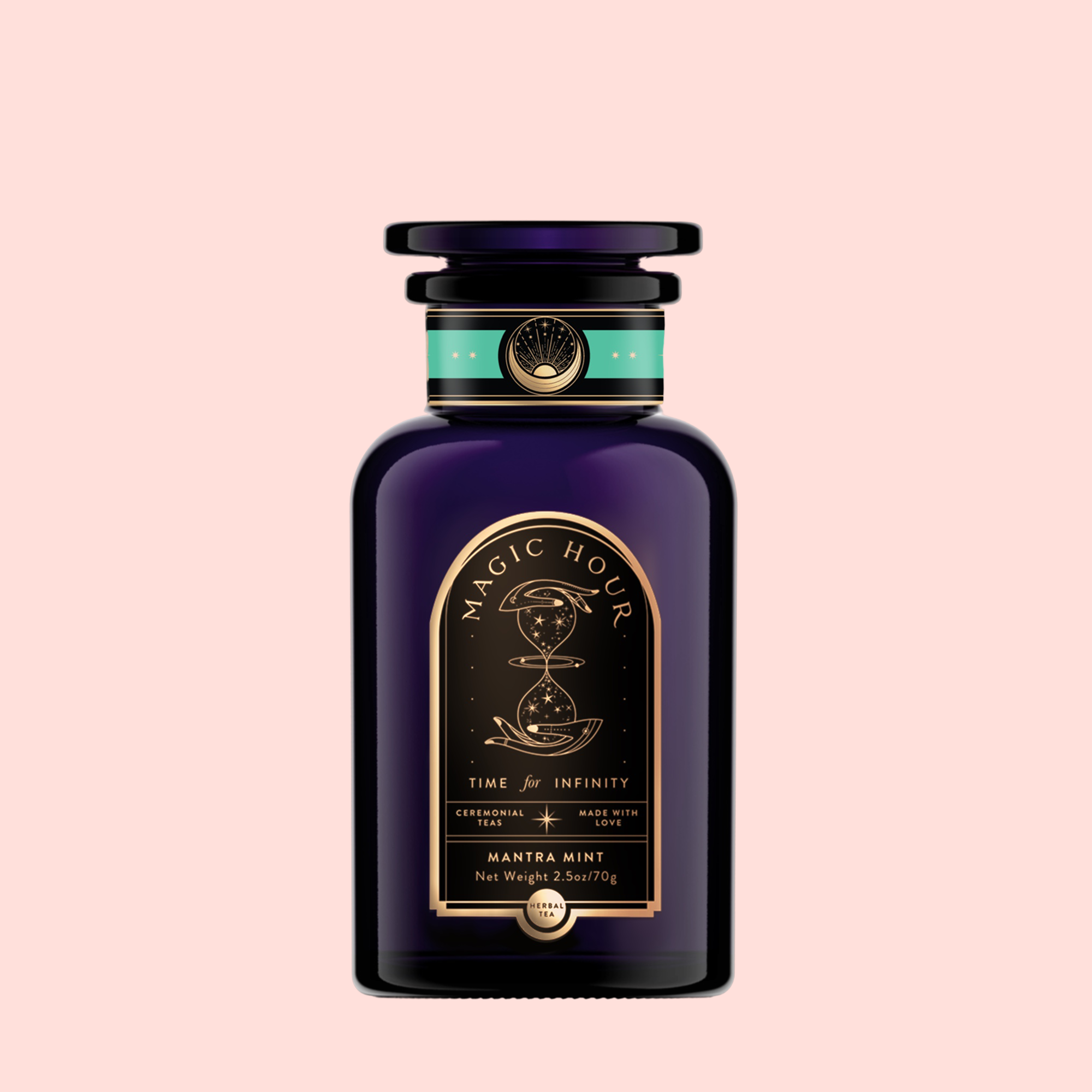 A dark purple glass jar labeled "Magic Hour" with gold and green accents, hourglass and celestial designs. Label reads "Time for Infinity" and "Mantra Mint™ Herbal Tea," an ashwagandha-infused, caffeine-free blend on a light pink background.