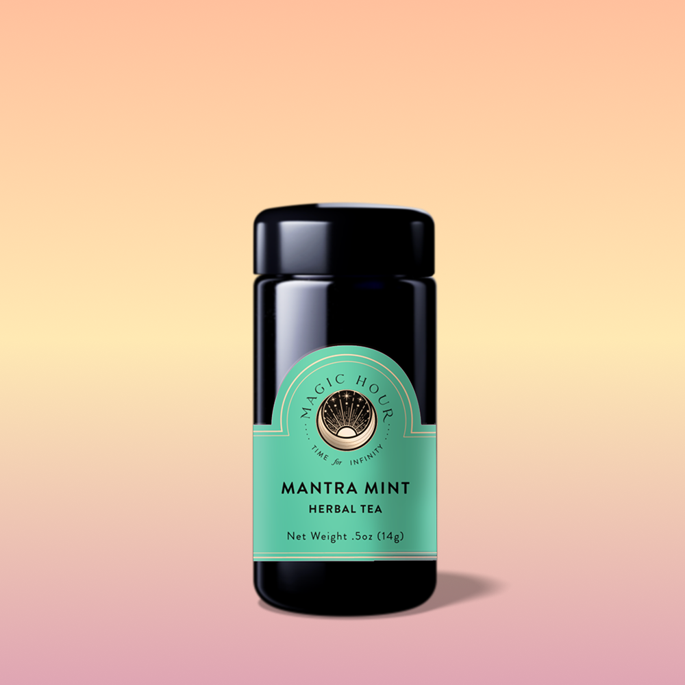 A black jar labeled “Mantra Mint™ Herbal Tea” with a mint green label sits on a soft peach, yellow, and pink gradient background. This caffeine-free blend features Ashwagandha and has a dark glossy lid with a subtle shadow beneath.