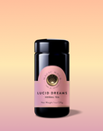 A black tea jar labeled "Lucid Dreams: Tulsi-Turmeric Herbal Tea for Sleep & Calm" with a pink and gold label, set against a peach-to-soft-pink gradient. A caffeine-free blend, the jar casts a soft shadow.
