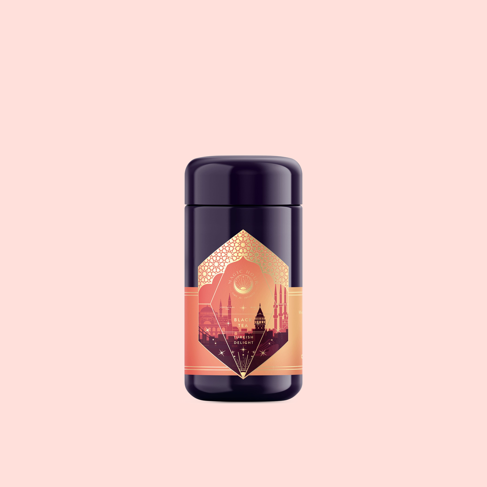 A dark purple and gold container with an ornate label featuring a cityscape silhouette and geometric designs evokes Istanbul, presenting "Turkish Delight" tea against a pale pink background.