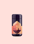 A dark purple and gold container with an ornate label featuring a cityscape silhouette and geometric designs evokes Istanbul, presenting "Turkish Delight" tea against a pale pink background.