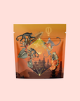 A vibrant coffee bag featuring monkeys, tropical leaves, and geometric shapes on an orange backdrop with pagodas and a hot air balloon—perfect for showcasing Bali Bliss: Coconut-Lime & Ginger-Melon White Tea.