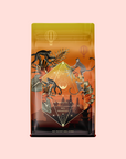 A vibrant coffee bag showcases illustrated monkeys, plants, and hot air balloons above a tropical scene. The geometric label reads "Bali Bliss: Coconut-Lime & Ginger-Melon White Tea," capturing the lively essence of this Bali tea blend.