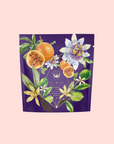 A purple tea package with colorful illustrations features “Romance in Ravello - Chocolate-Passionfruit-Rose-Cream White Tea,” a passion fruit blend inspired by the Amalfi Coast, with orange slices, flowers, and green leaves on a light pink background.