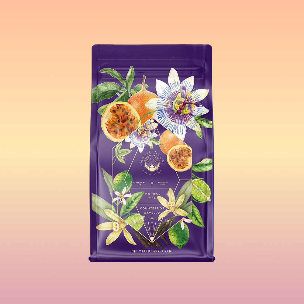 A purple tea bag displays vibrant passion fruits and florals on a soft peach-yellow gradient. The label reads "Romance in Ravello - Chocolate-Passionfruit-Rose-Cream White Tea," with gold geometric accents for an elegant touch.