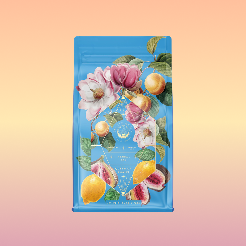 A bright blue tea package called "Summer in Amalfi" features illustrations of lemons, figs, peaches, and pink flowers on a soft peach-to-yellow gradient background, capturing the lively Mediterranean spirit.