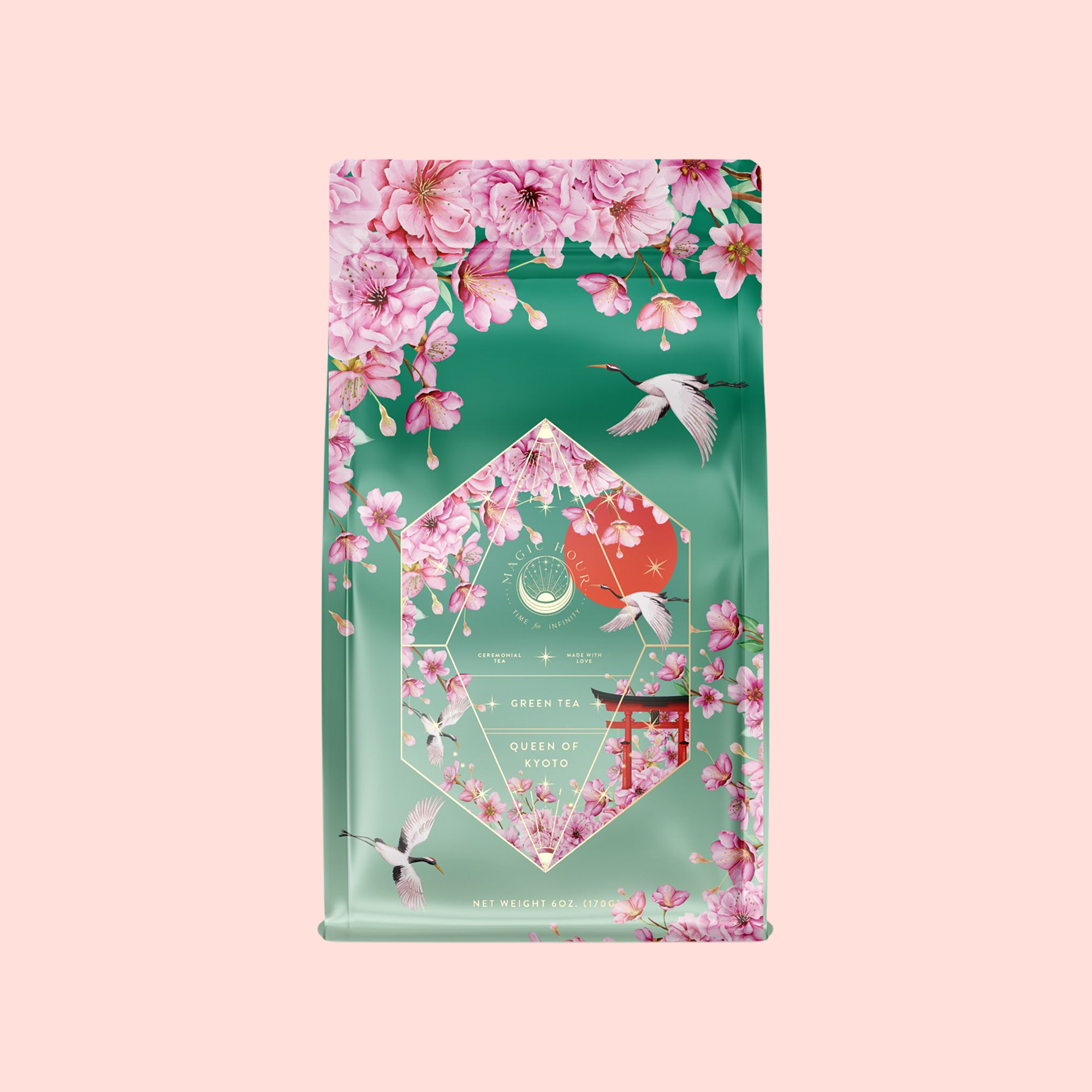 A green and pink tea bag of Queen of Kyoto features cherry blossoms, flying cranes, and floral art inspired by the Japanese Cherry Blossom Festival with "Green Tea, Queen of Kyoto" text on a soft pink background.