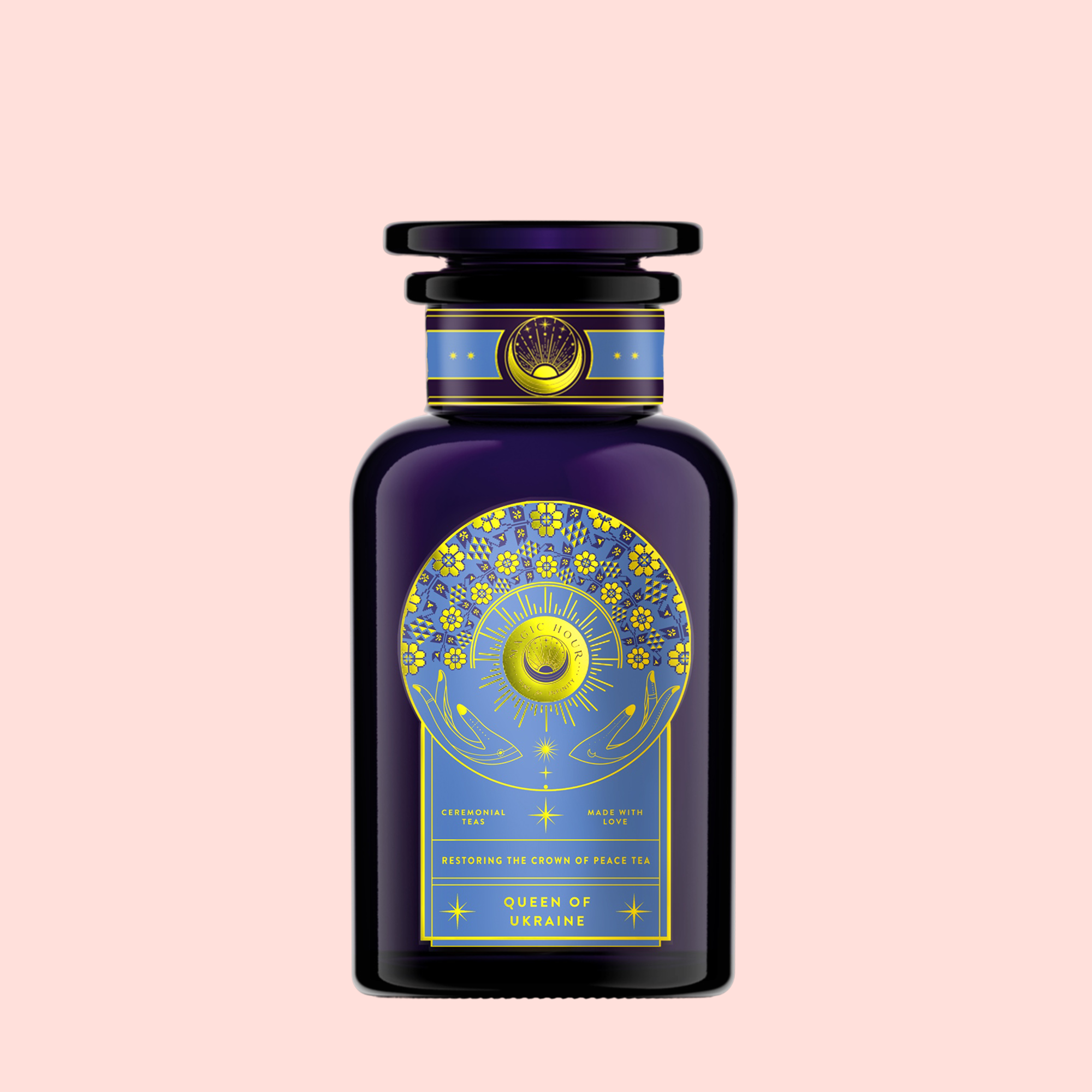 A dark blue bottle with a gold and blue celestial design labeled "Queen of Ukraine: Spring Blossom Tea" stands out on a pastel pink background—ideal for fans of butterfly pea flower or wild strawberry chamomile tea.