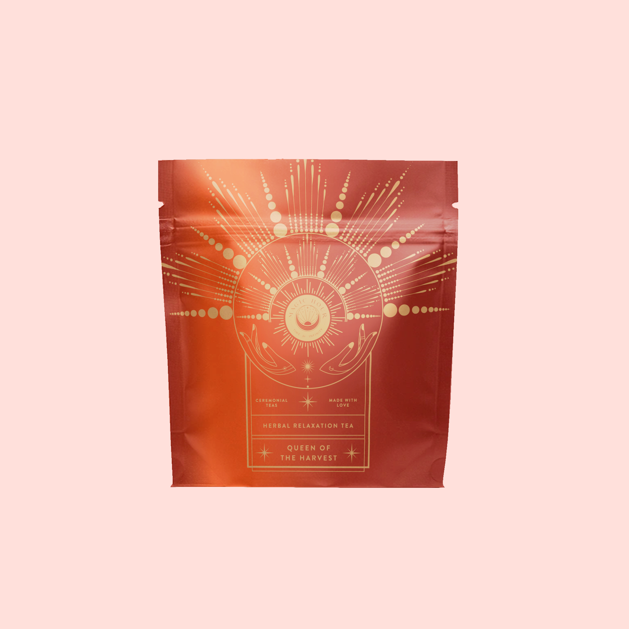 A red-orange tea package with gold celestial motifs—rays, stars, and hands—is labeled “Queen of the Harvest: Herbal Relaxation Tea.” This organic herbal blend stands out against a solid light pink background.