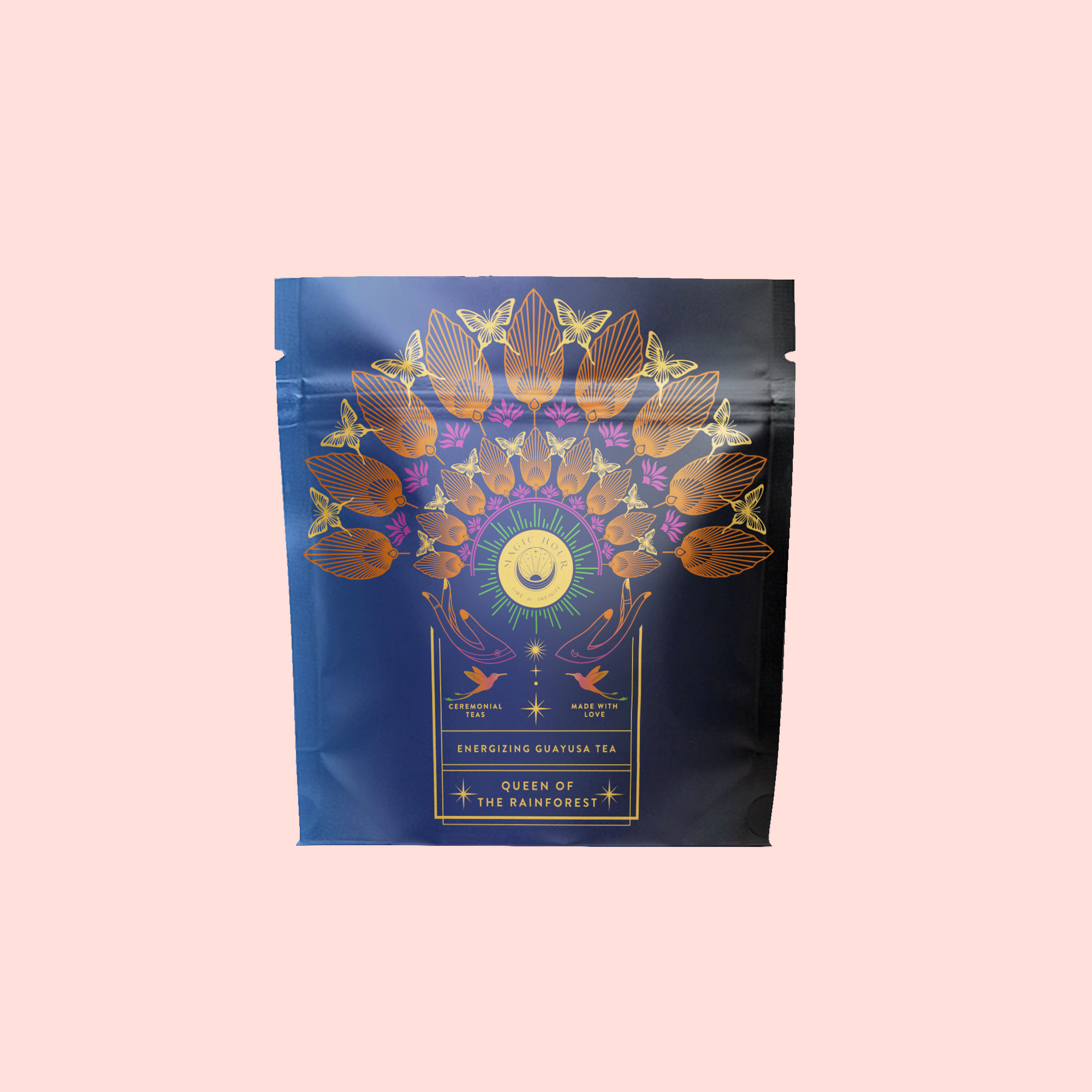 A navy blue tea package features gold and pink birds and leaves in a fan above a sun and crescent moon. The label reads "Queen of the Rainforest: Cacao-Berry Tea," an invigorating herbal blend for an energizing experience.